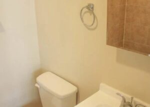 A bathroom corner with a white toilet and sink